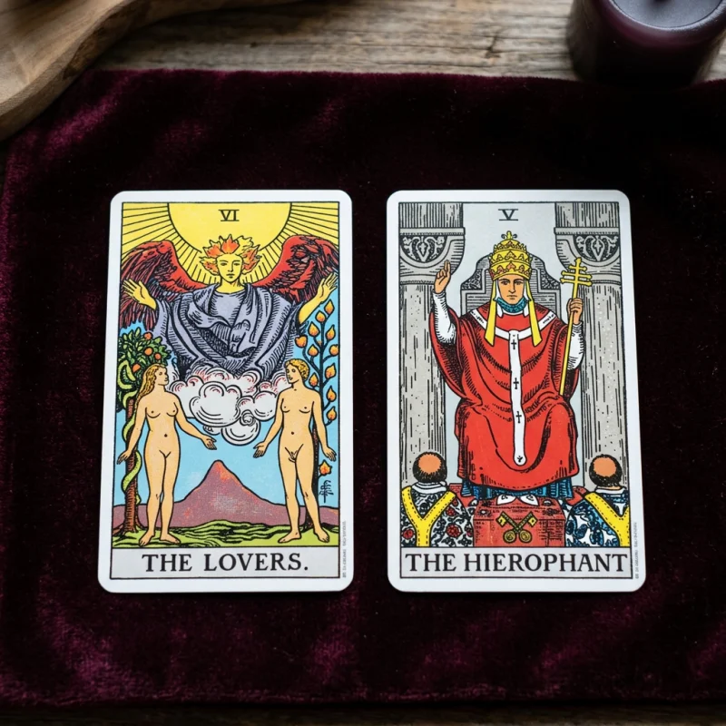 Die Tarotkarten Die Liebenden und Der Hohepriester nebeneinander auf einer dunklen Samtunterlage